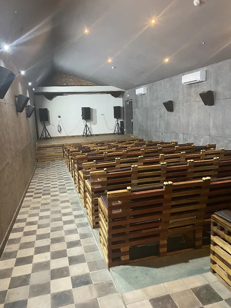 Salle de cinéma de l'Institut Français : gradins en bois et scène